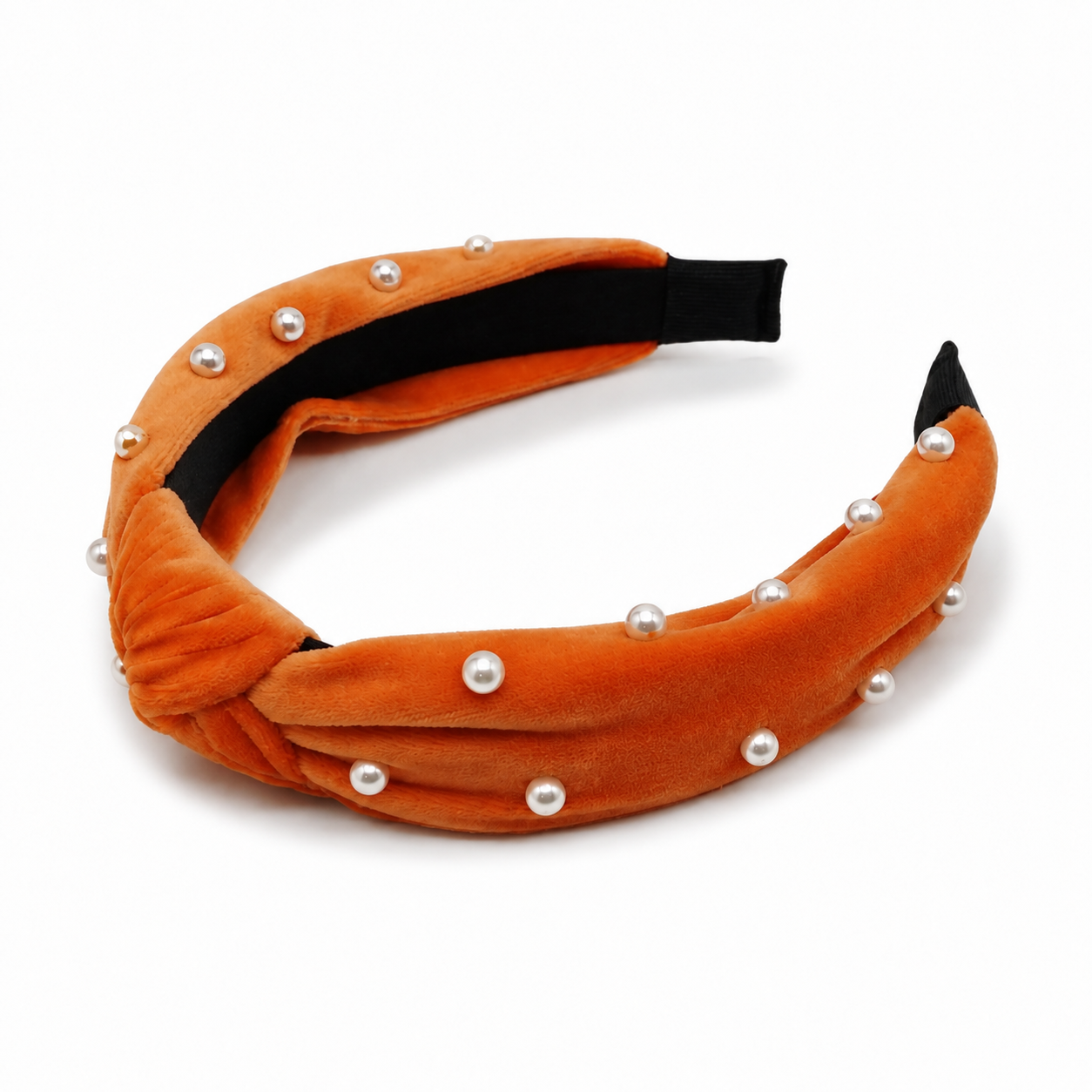 Angled studio view of orange velvet knotted headband with pearl accents and black inner band