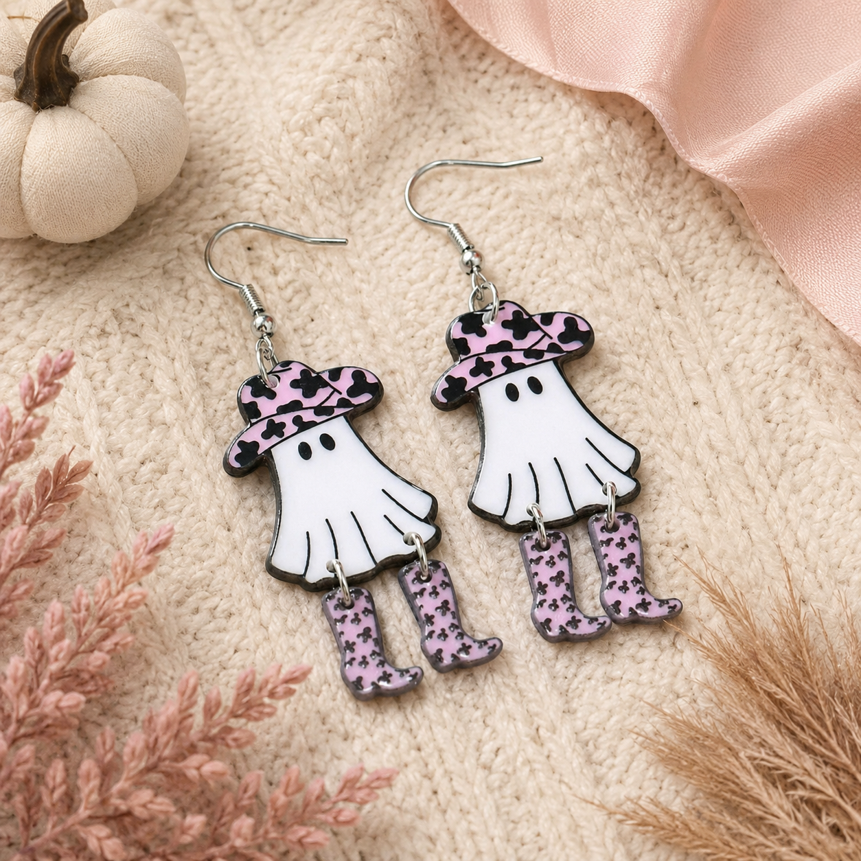 Close-up of western ghost earring with pink cow-print cowboy hat and dangling boots