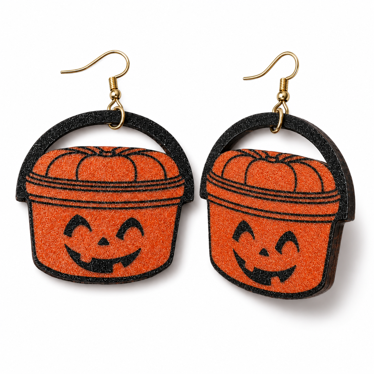A pair of Halloween bucket earrings made from glittery orange and black foam, featuring a jack-o'-lantern face and gold-tone fishhook ear wires, shown on a plain white background.