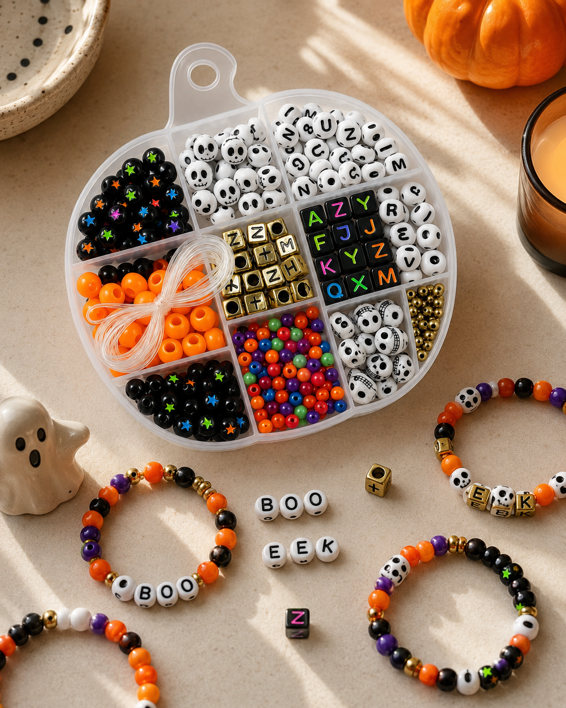 Halloween bracelet-making kit styled on a black background with pumpkins, ribbon and spooky seasonal accents