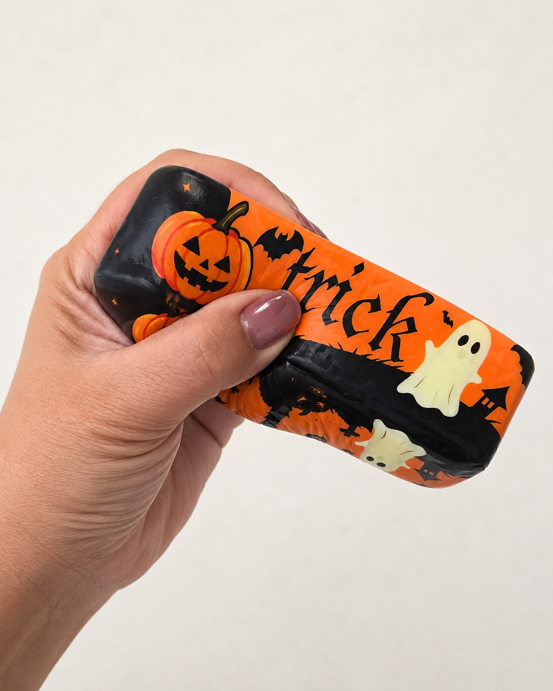 Trick or Treat Halloween butter squishy being squeezed by hand to demonstrate its soft slow-rise foam