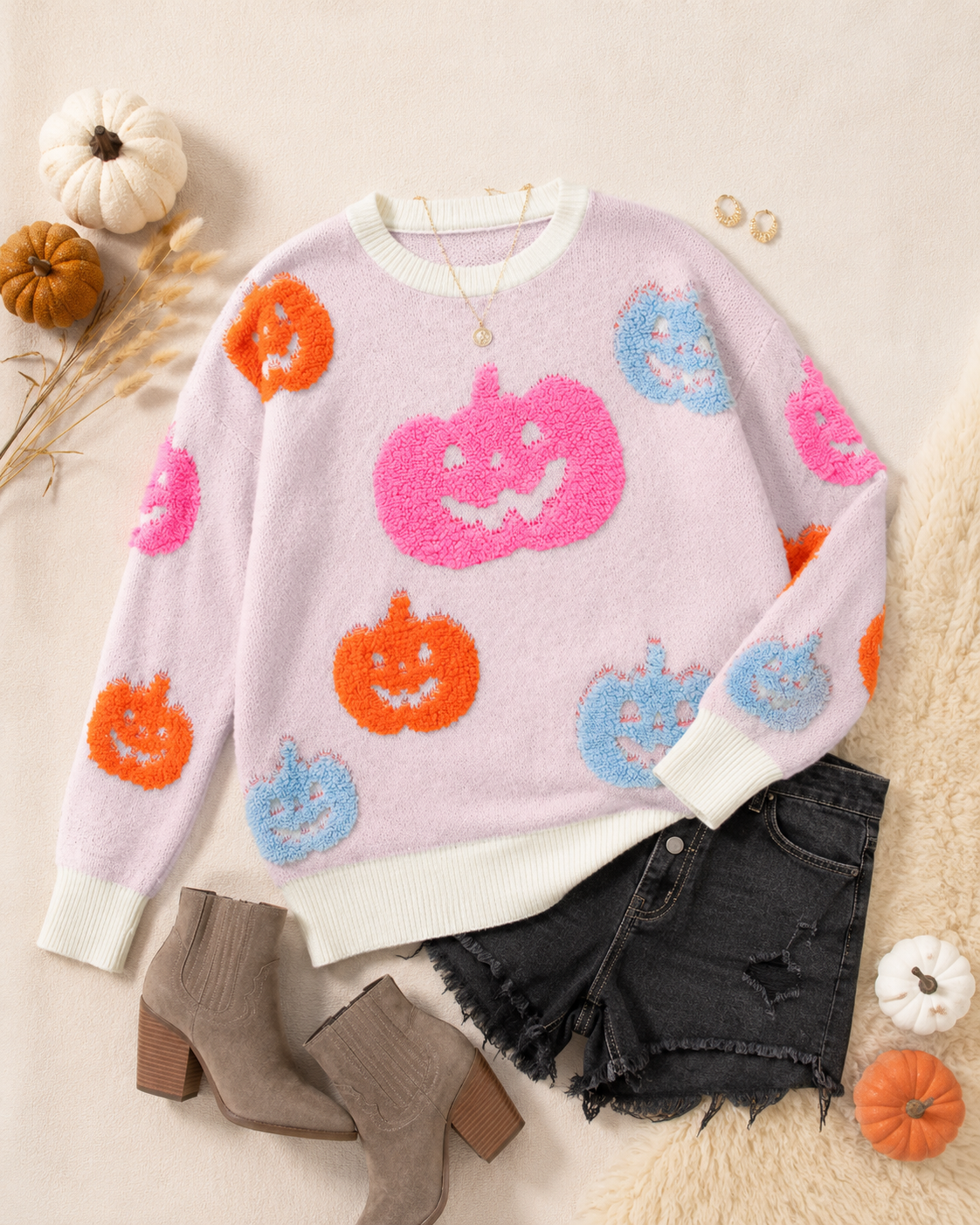 Flat lay of the Pumpkin Pop Halloween Knit Sweater styled with black denim, boots and fall accessories.