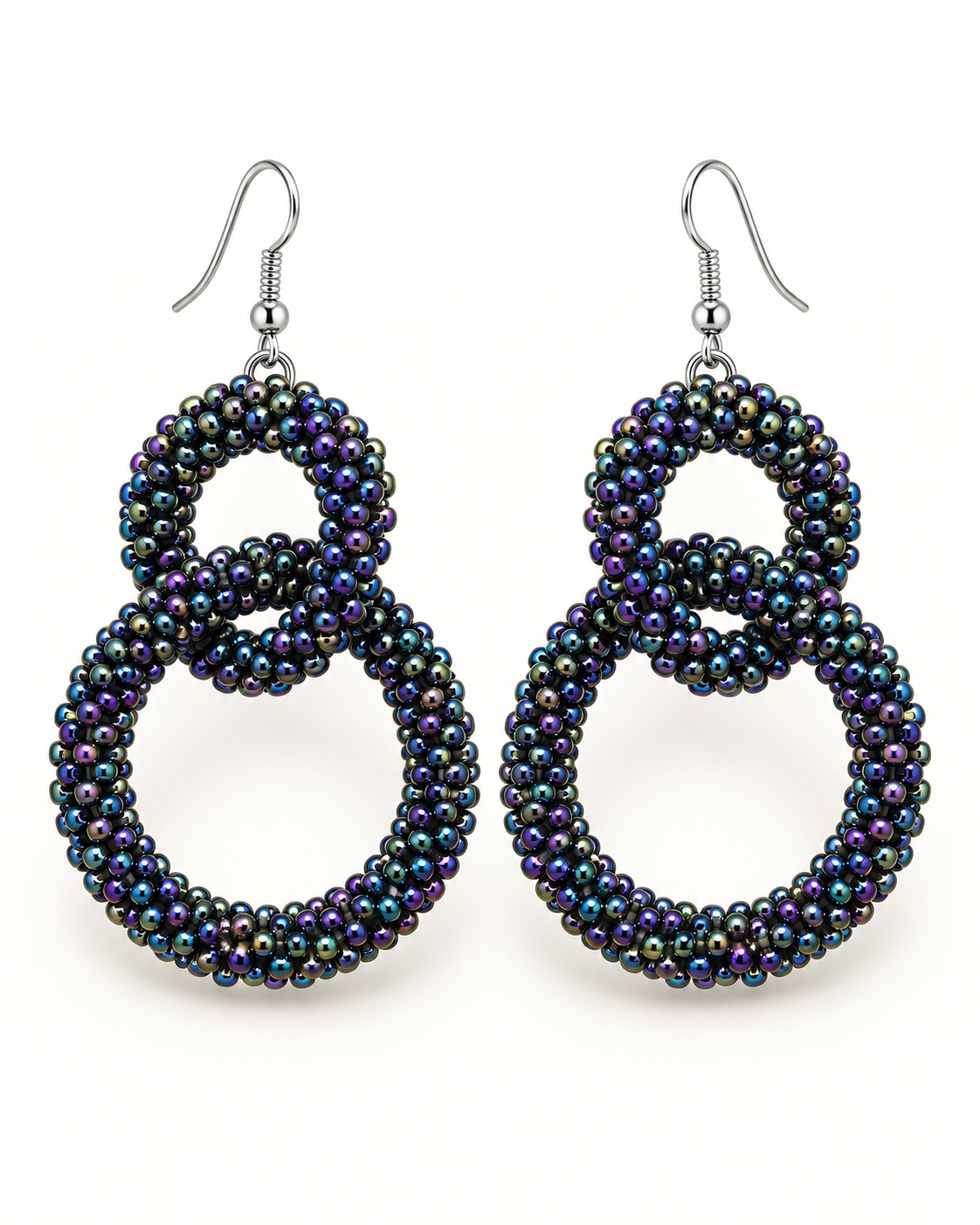A pair of large, double-loop dangle earrings made from iridescent seed beads that shift between black, purple, and blue, suspended from silver fishhook wires on a plain white background.