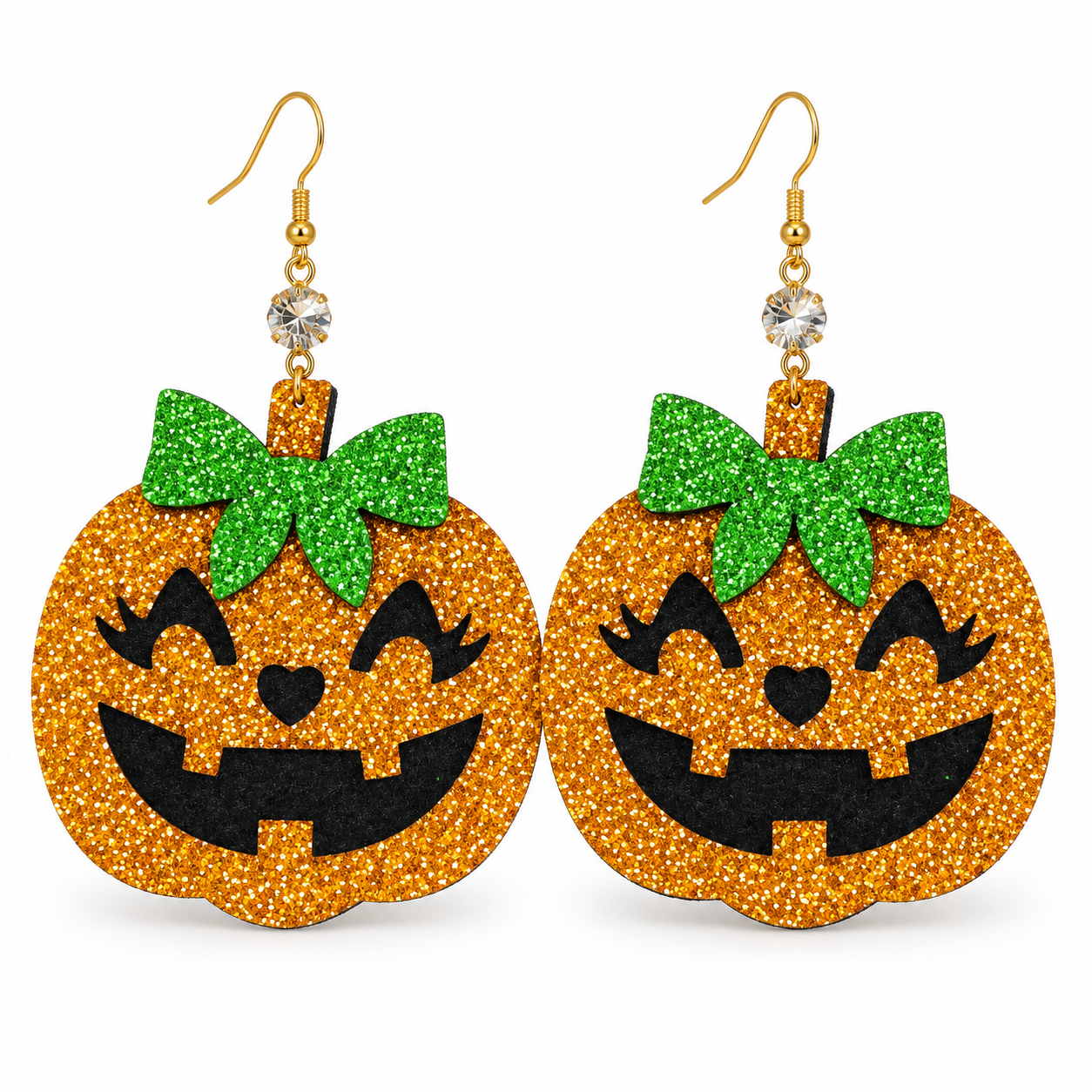 A pair of glittery orange jack-o'-lantern dangle earrings with green glitter bows, black glitter facial features, and gold-tone hooks with clear rhinestones, shown on a plain white background.