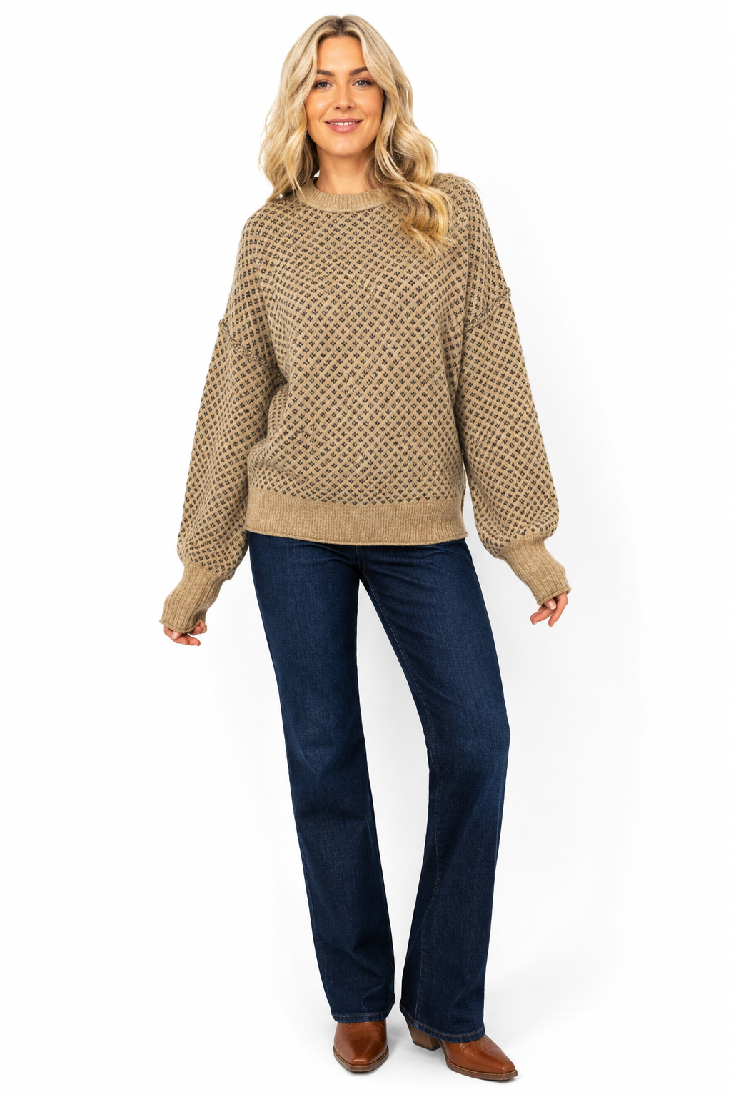 Woman wearing a khaki and charcoal geometric knit sweater with dark jeans and cognac Western boots on a white background.