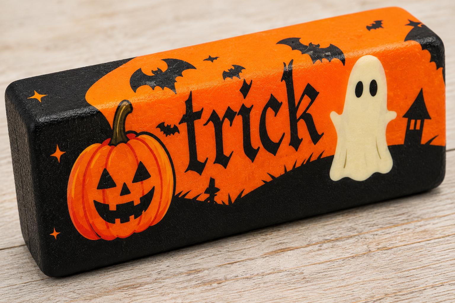 Close-up of Halloween slow-rise butter squishy showing soft foam texture, pumpkin, ghost, bats and Trick design