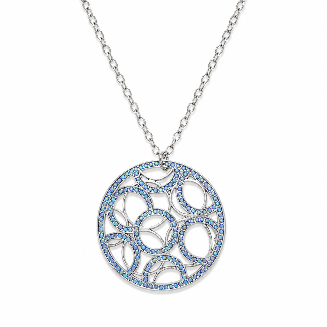 A silver-tone circular pendant necklace featuring an intricate openwork geometric pattern inlaid with small blue stones, suspended from a matching silver chain on a white background.