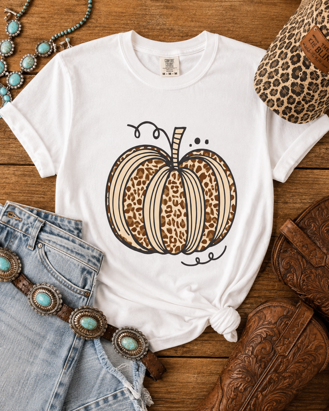 Flat lay of the Leopard Pumpkin Graphic Tee styled with denim, boots, turquoise jewelry, and fall accessories.