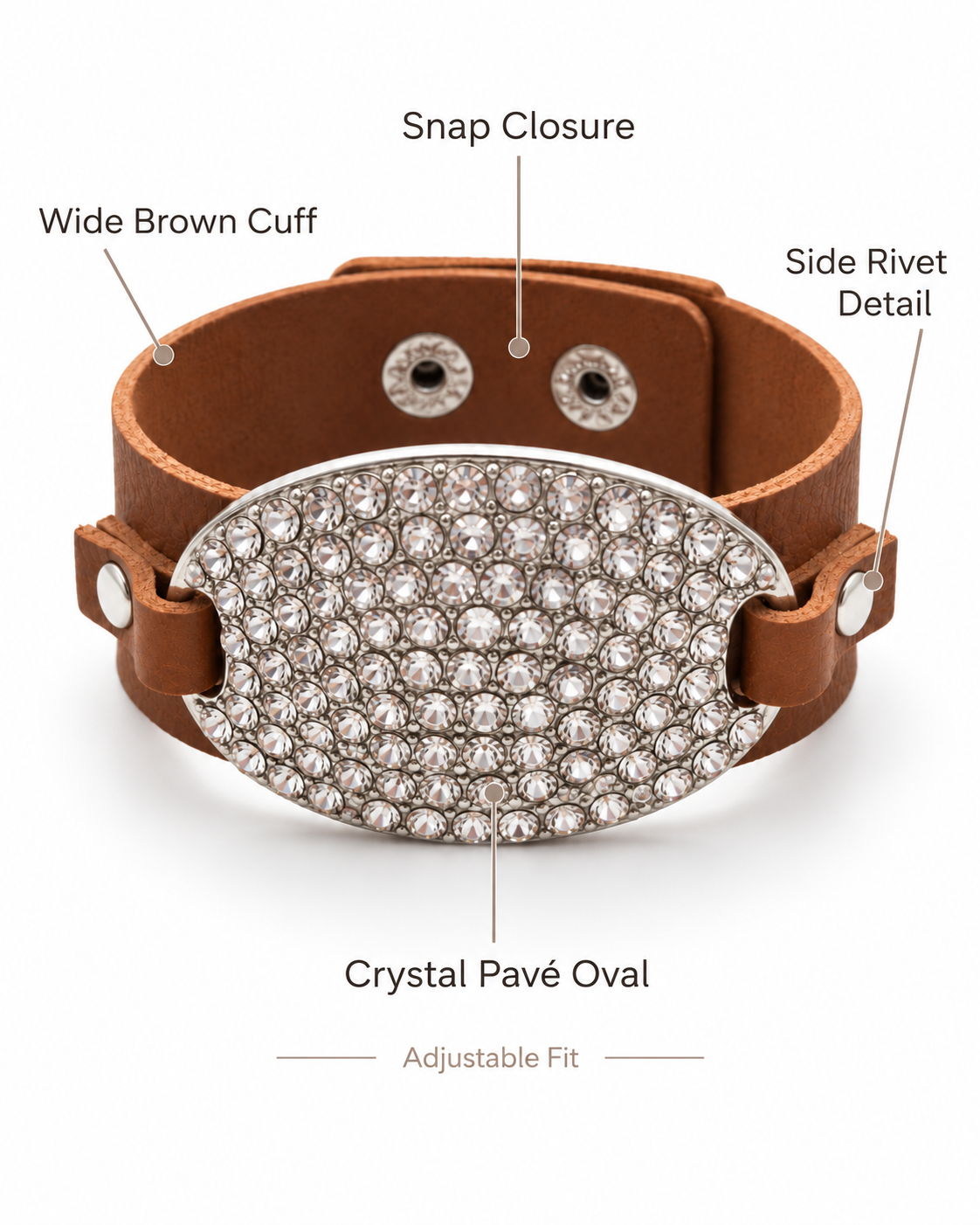 Brown leather adjustable cuff bracelet with a large crystal-paved oval centerpiece and labeled callouts for wide brown cuff, snap closure, side rivet detail, and crystal pavé oval.