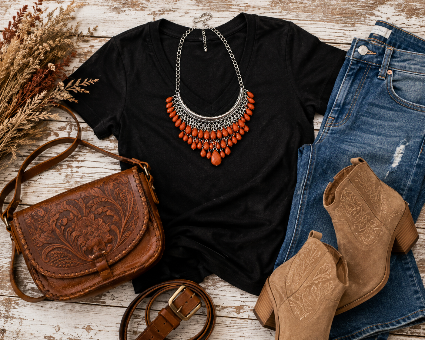 Ivory or black tee, medium-wash denim, cognac belt or bag, neutral bootie, and the necklace placed as the hero accessory