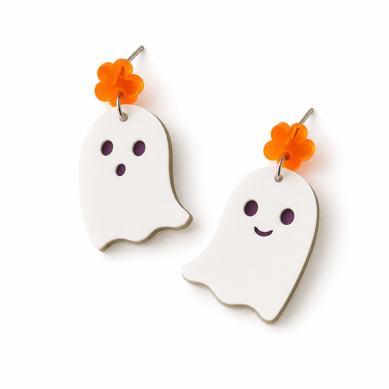 White ghost dangle earrings with cutout faces, bright orange flower studs, and silver-tone hardware on a clean white background.