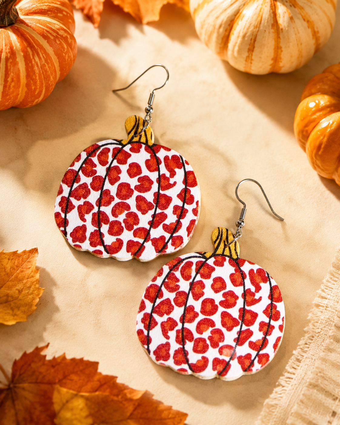 Wild Harvest Leopard Pumpkin Earrings styled with pumpkins, autumn leaves and warm neutral fall textures.