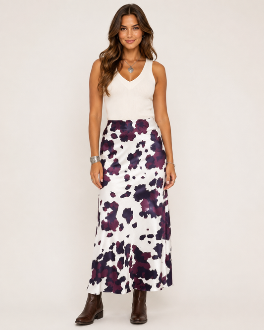 Brunette model wearing the Brown Abstract Western Maxi Skirt with a white tank and brown Western boots on a warm studio background.