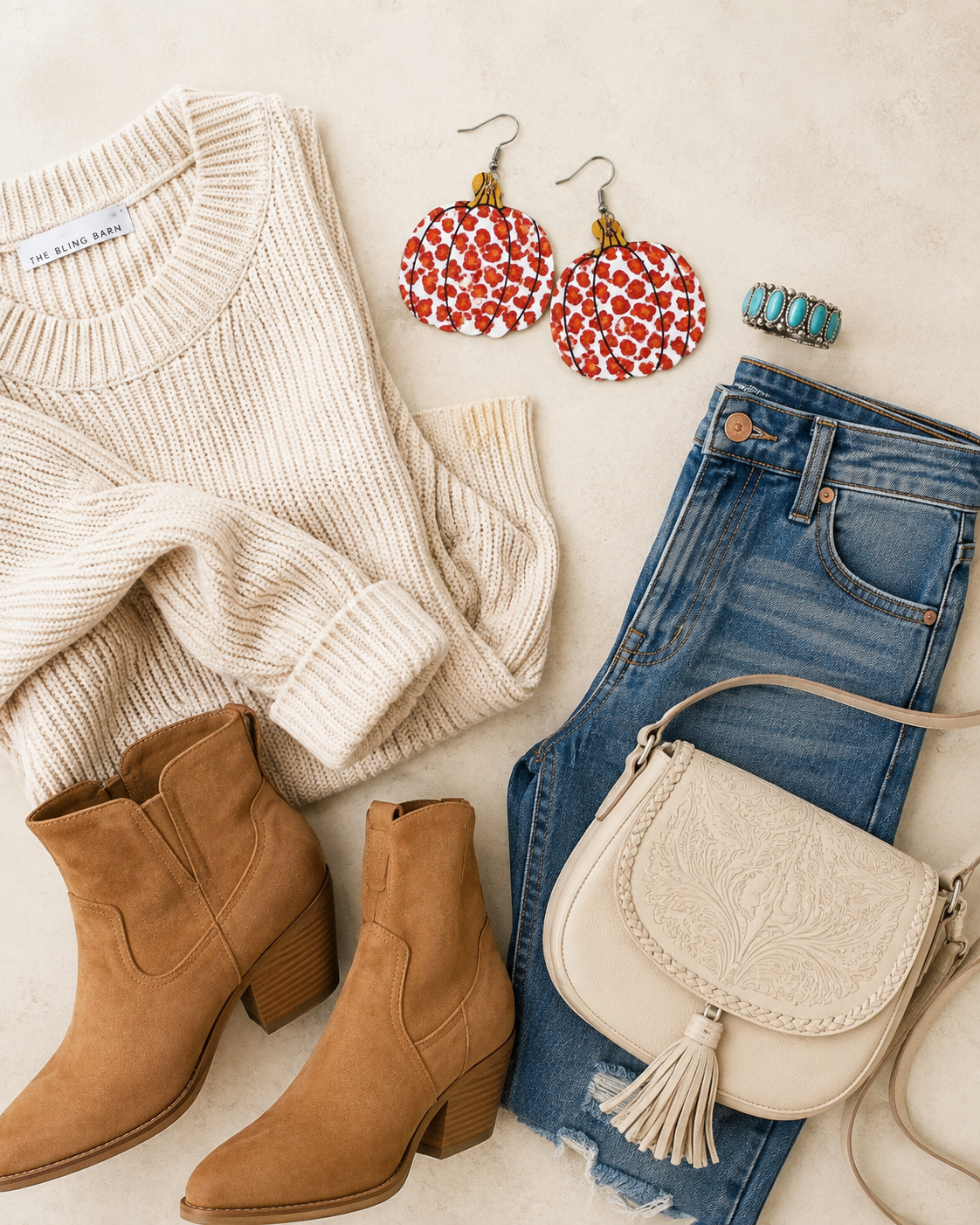 Flat lay of Wild Harvest Leopard Pumpkin Earrings with denim, cream knitwear, western boots and turquoise jewelry.
