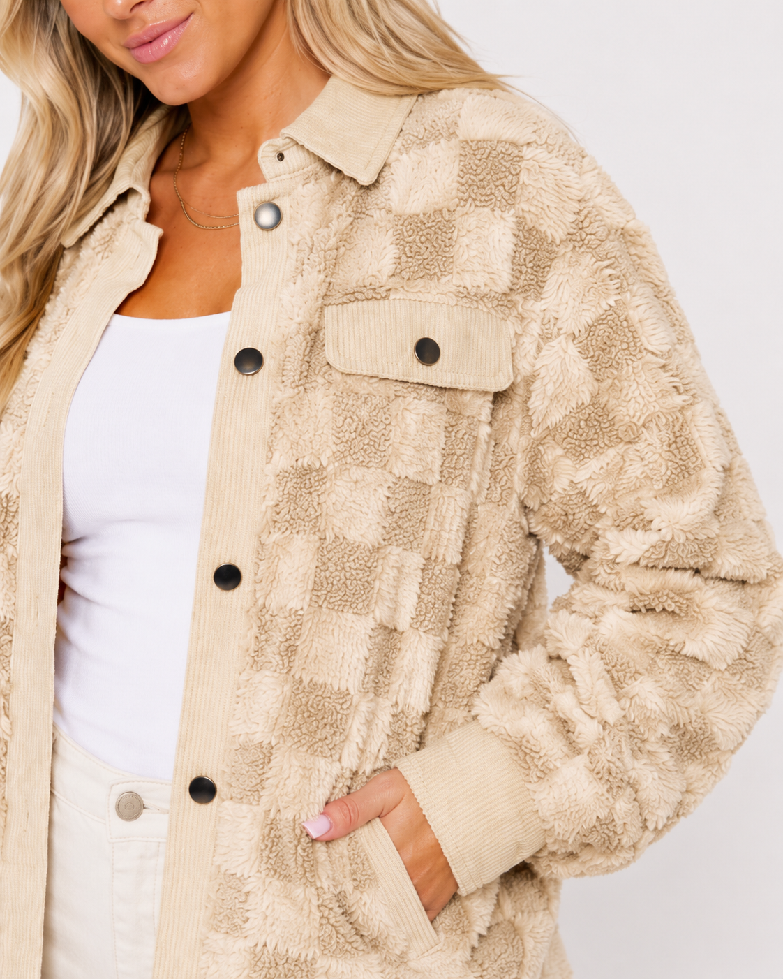 Close-up of the High Plains shacket showing plush checker texture, corduroy trim, metal snap buttons, chest pocket, and side pocket.
