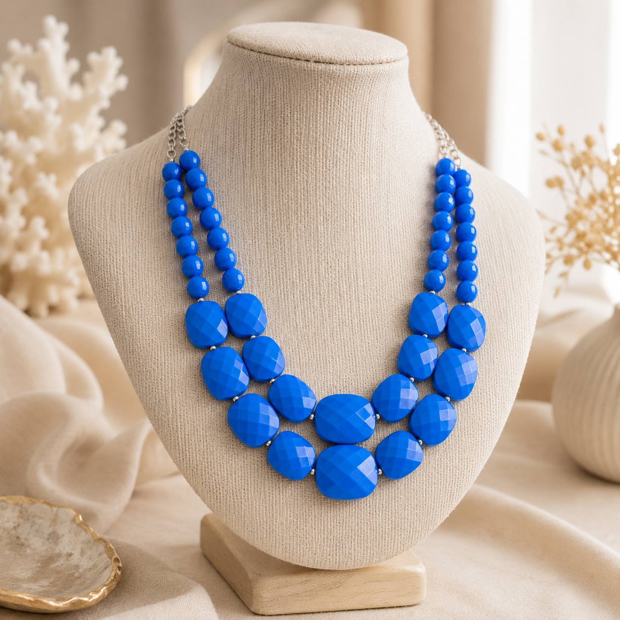 Cobalt blue double-strand statement necklace displayed on a neutral jewelry bust
