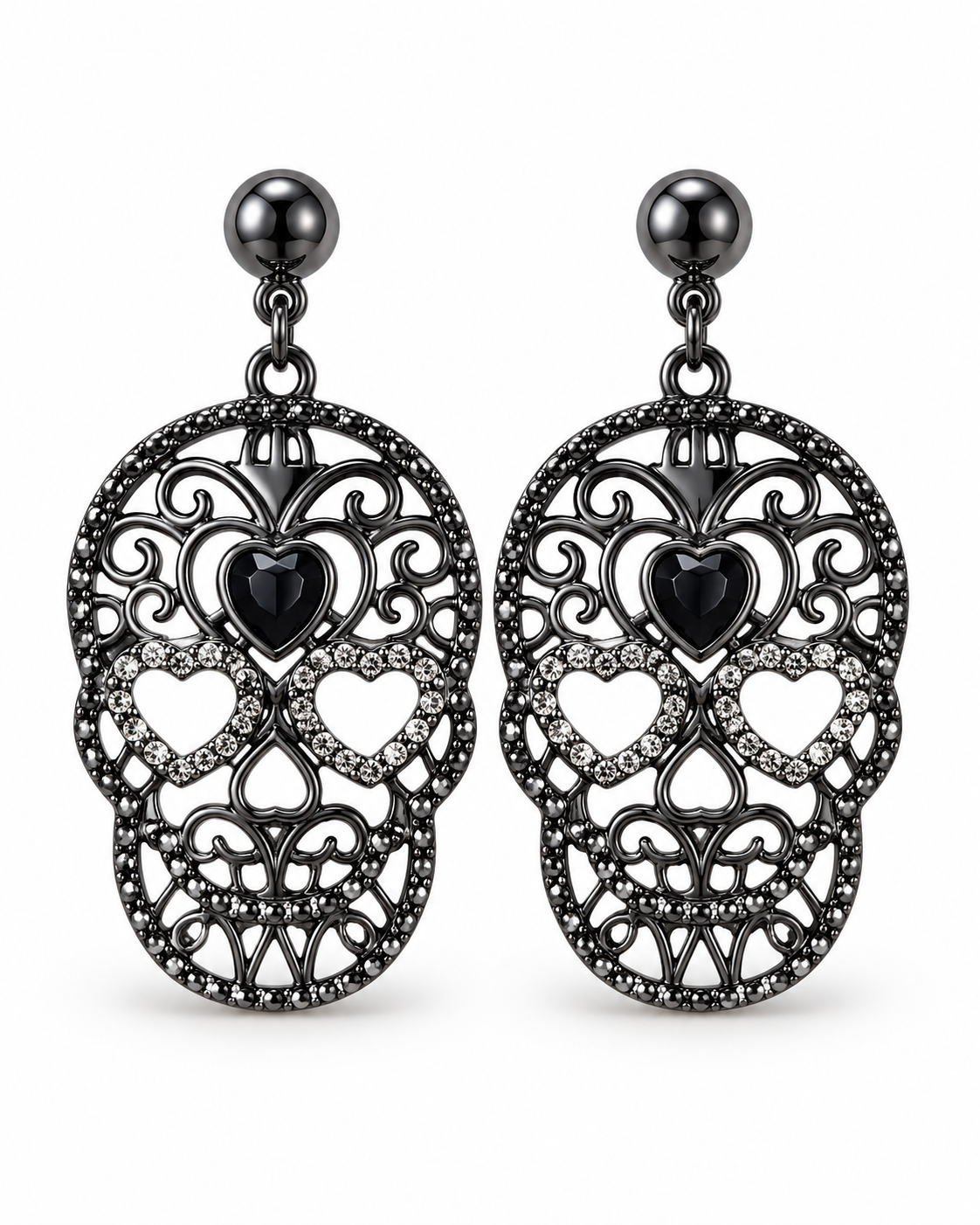 A pair of gothic-style drop earrings featuring intricate filigree sugar skull designs in black metal, adorned with small clear rhinestones and a central black heart-shaped stone, suspended from dark metallic ball studs.