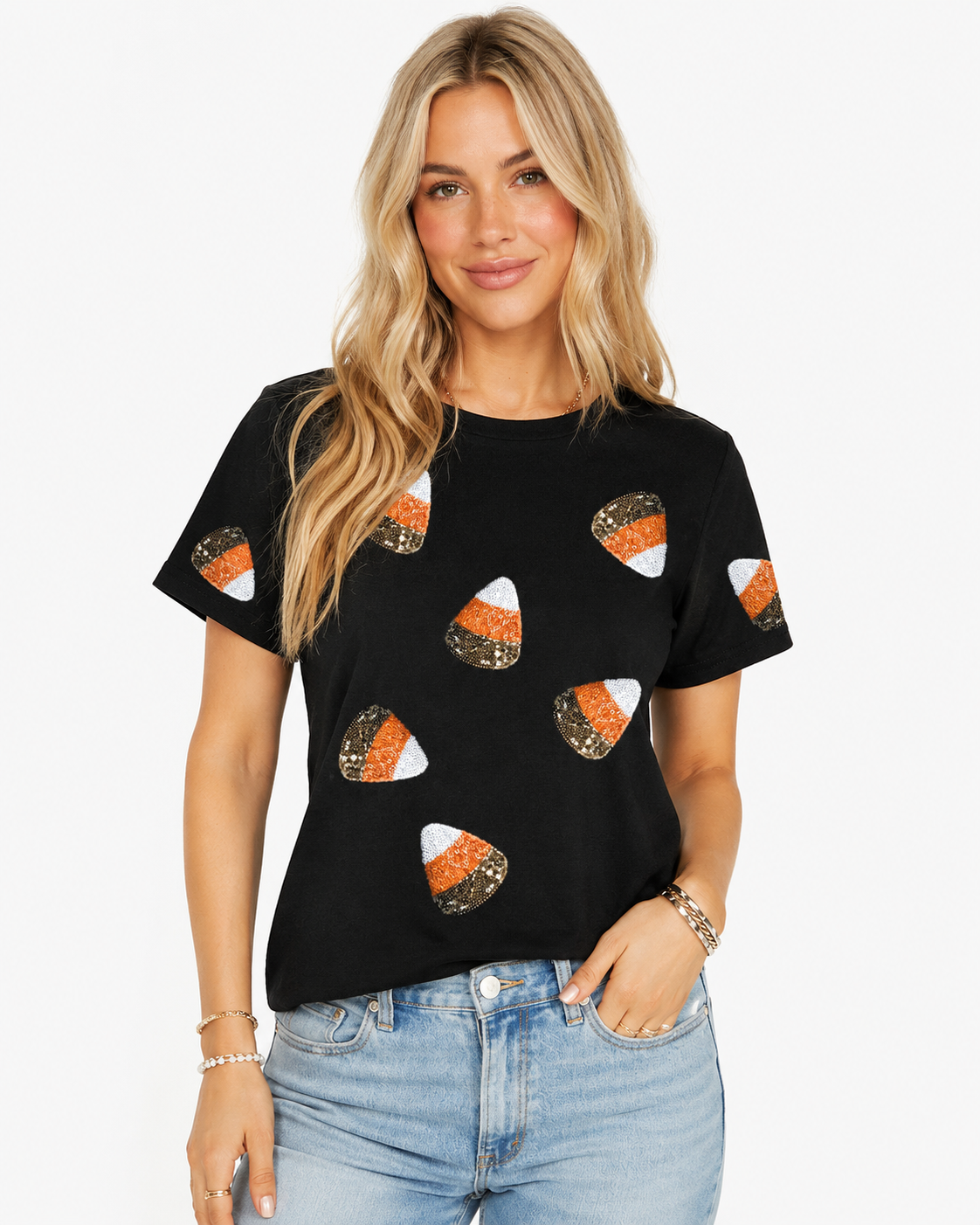 Black sequin candy corn Halloween T-shirt styled with light-wash denim on a white background.